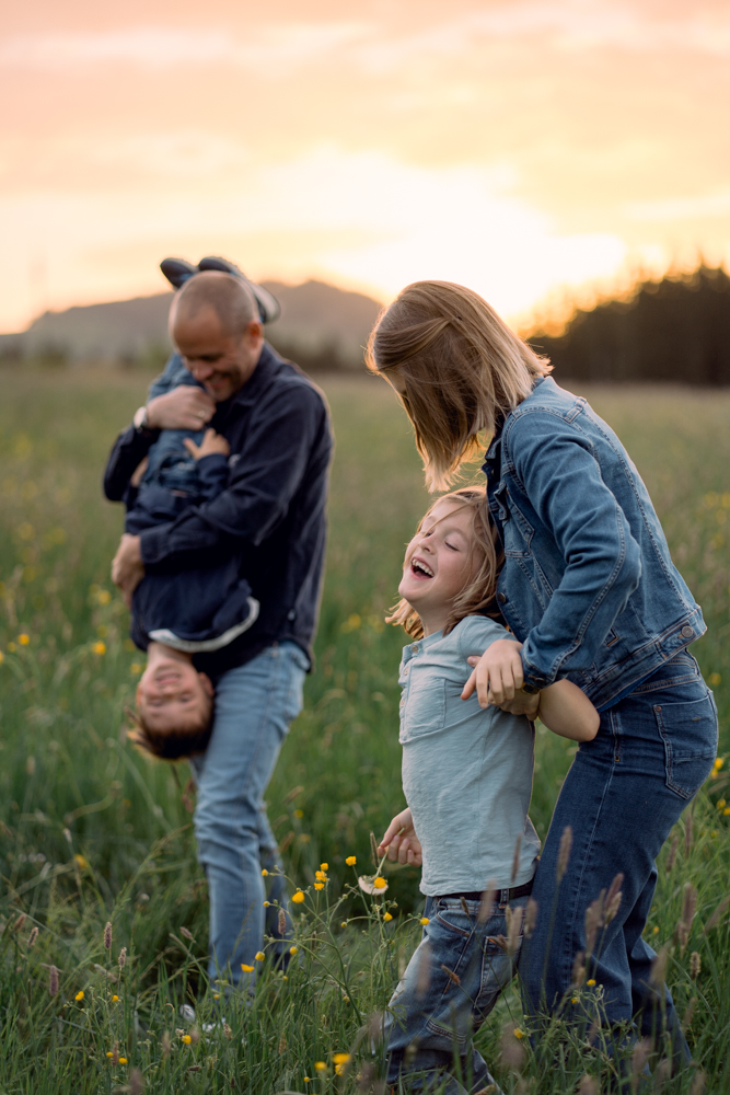 Familie mit Mama, Papa und zwei Kinder beim Familienshooting auf einer Wiese im Allgäu durch Fotografin fotografiert