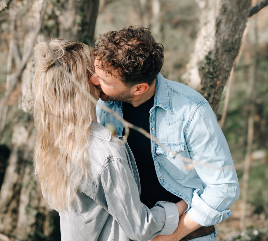 Bild eines Pärchens wo der Mann die Frau auf die Wange küsst bei einem im Allgäu fotografierten Paarshooting durch eine Fotografin