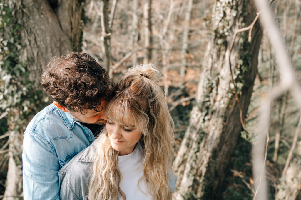 Bild eines Pärchens wo der Mann die Frau auf die Wange küsst bei einem im Allgäu fotografierten Paarshooting durch eine Fotografin